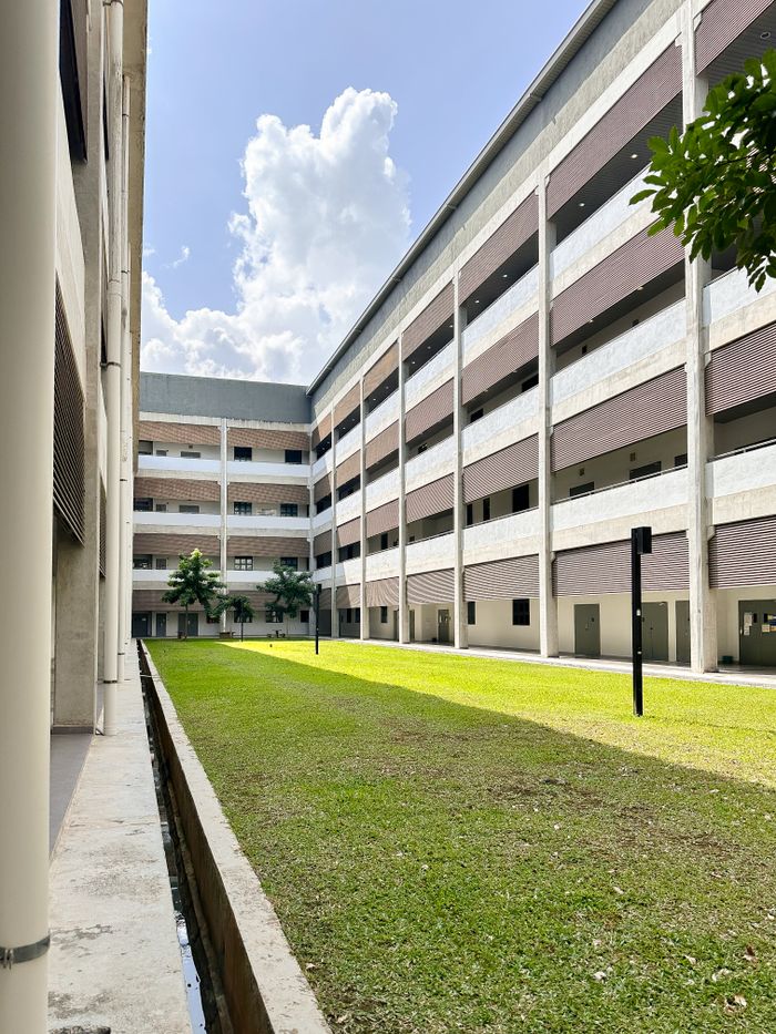 Spacious modern building with courtyard and blue sky, perfect for education themes.